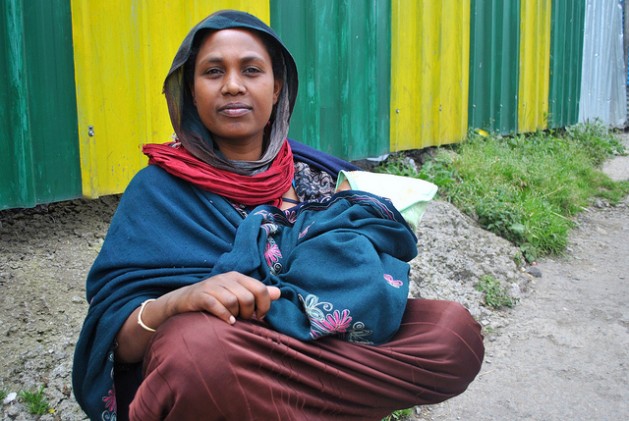 Bosena, 25, sits on the side of a busy road in Addis Ababa, Ethiopia’s capital, with a baby in her arms. Ethiopia is among the countries listed as having made significant progress in reducing child and maternal mortality rates. Credit: Jacey Fortin/IPS