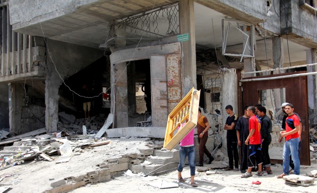 Following an Israeli airstrike, Palestinian youth inspect the building their families lived in. Credit: Khaled Alashqar/IPS