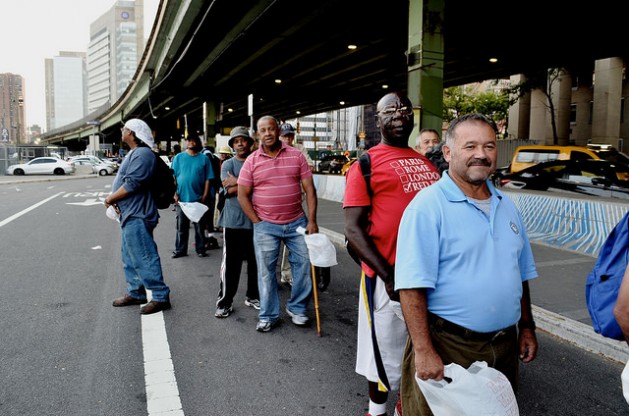 Men line up to receive food distributed by Coalition for the Homeless volunteers at 35th St, FDR Drive, in New York City. Credit: Zafirah Mohamed Zein/IPS