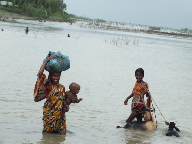 Families who live on Ã¢Â€Â˜charsÃ¢Â€Â™ Ã¢Â€Â“ river islands formed from sedimentation Ã¢Â€Â“ are extremely vulnerable to natural disasters. This family wades through floodwaters left behind after heavy rains in August caused major rivers to burst their banks in northern Bangladesh.