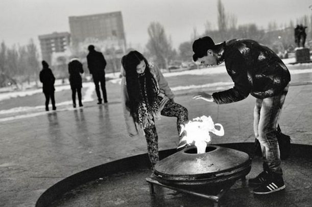 Young people heat themselves by the eternal flame at a WWII monument in Bishkek last February. Each winter in Kyrgyzstan the energy situation seems to worsen; blackouts last longer, and officials seem less able to do anything to improve conditions. This year is expected to be particularly difficult. Credit: David Trilling/EurasiaNet