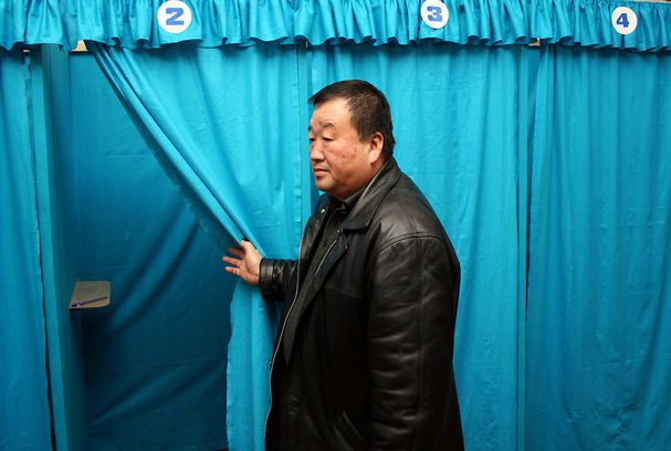 The chairman of a Tashkent polling station opens a curtain to a voting booth during the Uzbek presidential election of December 2007. UzbekistanÃ¢Â€Â™s Dec. 21 parliamentary elections feature only four staunchly pro-regime parties to fill the 150-seat lower house, or the Legislative Chamber. No opposition parties are permitted to legally exist in Uzbekistan, and independent candidates are barred from standing. Credit: OSCE