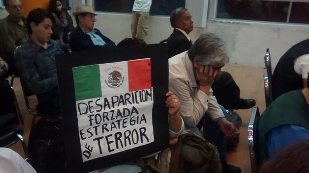 “Forced disappearance, a strategy of terror” reads a sign with the Mexican flag, held by a family member during a Feb. 19 ceremony to celebrate the 15th year anniversary of HIJOS, one of the first organisations created by the families of ‘desaparecidos’ to search for their loved ones and fight for justice. Credit: Emilio Godoy/IPS