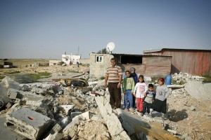 Naif Agele stands with his children and nephews by the ruins of his brother's house in an ‘unrecognised’ section of the township of Kuseife in the Negev desert. The house took one month to build and was demolished by government authorities in 10 minutes in March 2014. Credit: Silvia Boarini/IPS