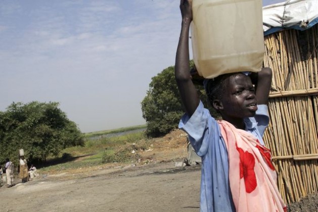A young Sudanese boy carries water home for his family in a plastic container. Credit: UN Photo/Tim McKulka