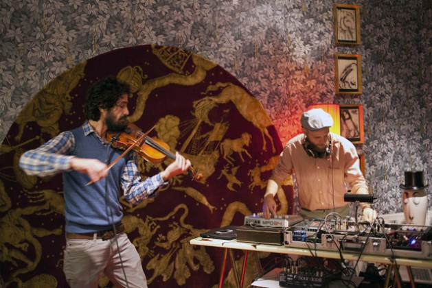 Alaa Arsheed, Syrian refugee and violinist, and Gian Pietro Masa, experimental electronic musician,  during their live peromance at the inauguration of Fornasetti's Calendarium exhibition.  Credit: Fornasetti / IPS