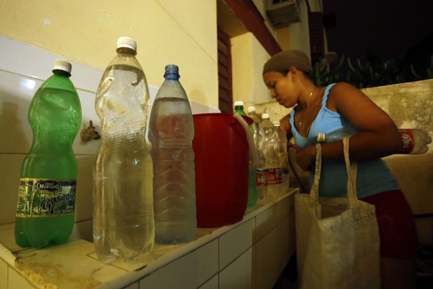A resident of the East Havana municipality arranges the containers of drinking water that she has brought home, after days without piped water in her home in the Cuban capital. Fetching water for household use has been added to the day-to-day tasks of women in Havana. Credit: Jorge Luis Baños/IPS