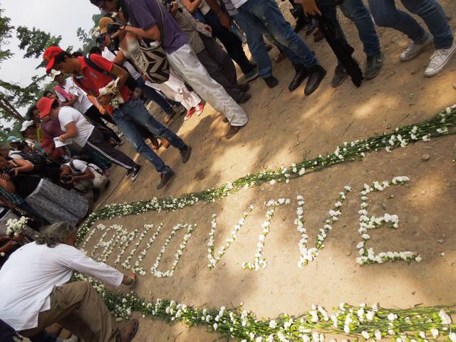 Camilo Lives” was written with white carnations in the dirt road leading from the river port of Barrancabermeja to the municipality of El Carmen de Chucurí, in the northeastern Colombian department of Santander. Some 700 people participated in the pilgrimage in homage to Camilo Torres on the 50th anniversary of his death in combat near this spot, on Feb. 15, 1966. Credit: Constanza Vieira/IPS