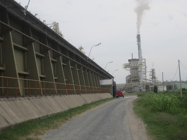 One side of the Angostura Agroindustrial Complex SA (CAIASA) storage facility, with the central plant visible in the background. The steam released by the furnace is the only smoke seen in this soy crushing plant, which does not use fossil fuels and generates virtually no waste products, on the banks of the Paraguay river in the municipality of Villeta, Paraguay. Credit: Mario Osava/IPS