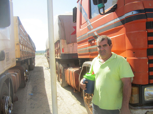 Martin Echauri says the Angostura Agroindustrial Complex SA (CAIASA) is “a blessing” because of how quickly he and his fellow truckers manage to unload the soybeans they haul in to the plant, which receives an average of 500 trucks a day in Angostura, in the industrial park in Villeta, Paraguay. While they wait, Echauri and other truckers drink “yerba mate”, a caffeinated herbal brew that is popular in Paraguay, Argentina, Uruguay and southern Brazil, which they drink in a special thermos. Credit: Mario Osava/IPS