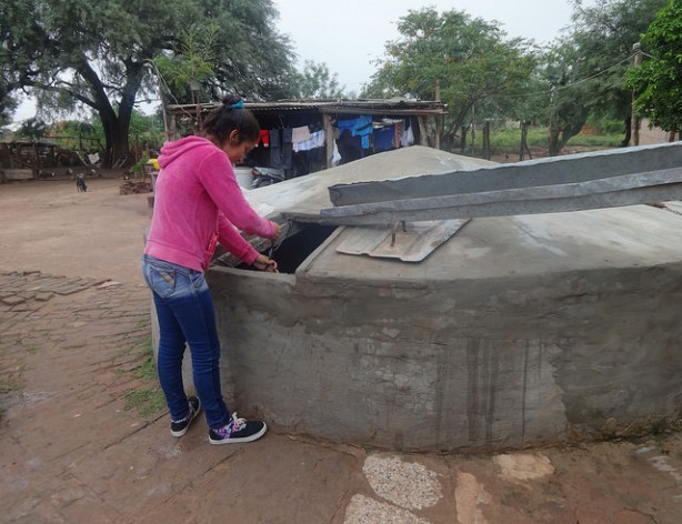 Jésica Garay, a young mother who is studying to become a teacher, gets water from the family tank built next to her humble home in the rural municipality of Corzuela in the northeast Argentine province of Chaco. Credit: Fabiana Frayssinet/IPS