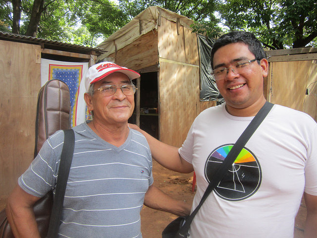 Néstor Colman, one of those evacuated due to the flooding of the Paraguay river in Bañado Sur in Asunción, next to Cleto Pérez, founder of the 1811 Movement which is organising the struggles of the residents of the Bañados neighbourhoods. Behind them is Colman’s kiosk in one of the makeshift shelters of the evacuees. Credit: Mario Osava/IPS