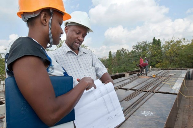 Martha Daniel, a female engineer inspecting engineering designs with her mentor at a construction site in Dar es Salaam. Credit: Kizito Makoye/IPS