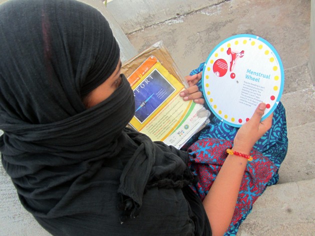 A high school student in eastern India, studies a leaflet on menstrual hygiene. Credit: Stella Paul/IPS