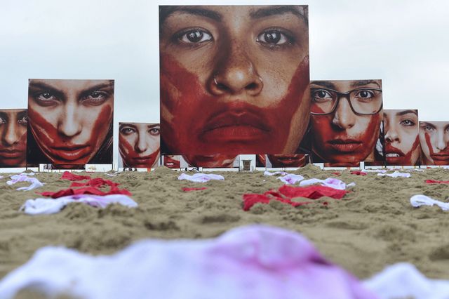 The Rio Peace organisation covered the sand on Copacabana beach, in the city of Rio de Janeiro, with blood-red or bloody women’s underwear and giant photos of women’s faces, also bloodied, representing the women who have been murdered in Brazil. Credit: Tânia Rêgo/Agência Brasil