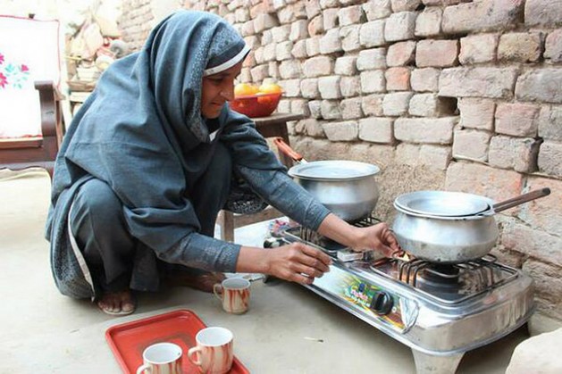 Nabela Zainab prepares tea on the biogas stove in her home in Faisalabad, Pakistan. The stove has eased indoor air pollution and restored her health. Credit: Saleem Shaikh/IPS