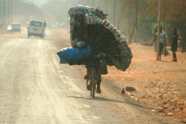 A Congolese man transports charcoal on his bicycle outside Lubumbashi in the DRC. An estimated 138 million poor households spend 10 billion dollars annually on energy-related products such as charcoal, candles, kerosene and firewood. Credit: Miriam Mannak/IPS