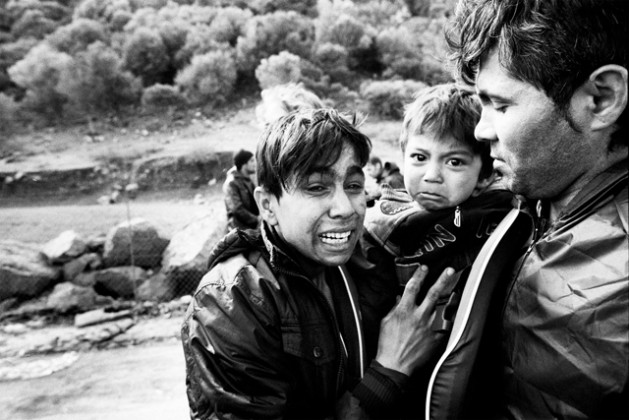 With fear etched on their faces, clearly still suffering from the trauma of a rough by boat across the Aegean, an Afghan family arrives in Lesvos, Greece (2015). Photo credit: UNHCR/Giles Duley