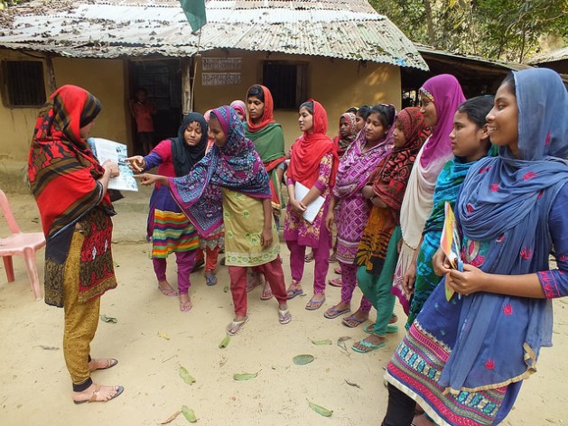 A group of girls attend a Shonglap session in Cox's Bazar, Bangladesh. The peer leader (left) is discussing adolescent legal rights. Credit: Naimul Haq/IPS