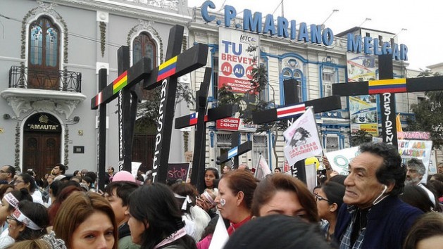 A group of demonstrators with black crosses, symbolising the victims of femicide in Peru and other countries of Latin America, march down a street in the centre of Lima during an Aug. 13 march against gender violence. Credit: Noemí Melgarejo/IPS