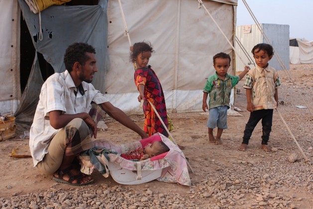 A Yemeni man proudly watching over an infant in the camp. Credit: James Jeffrey/IPS