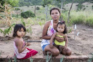Ines Terodoro dos Santos, 17, with her daughters, Eliara, 14-months, right, and Isabel, 3-years-old, in the family garden at home, in Aldeia Segredo Velho, near Ribeira do Pombal, in the state of Bahia, Brazil, on Wednesday, April 13, 2016. Credit: ©IFAD/Lianne Milton/Panos