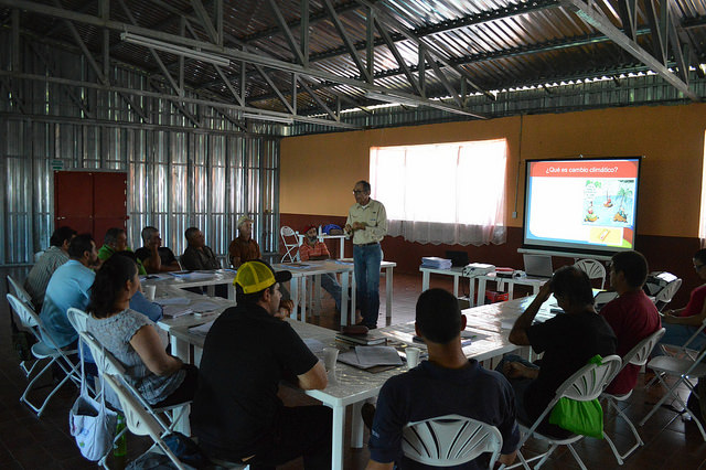 Farmers listen to Elías de Melo’s presentation, at the Llano Bonito Community Centre in León Cortés, Costa Rica, in a workshop aimed at training them in the adaptation of their coffee plantations to the raise in temperatures. Credit: Diego Arguedas Ortiz/IPS