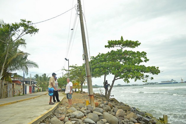 Reynaldo Charles and Ezequiel Hudson talk with Elicer Quesada (left to right) about the state of the breakwater on which they are standing. This is the part where the waves reach closest to the houses, and at high tide the water crosses over the new bicycle lane and the street and reaches the homes, in the town of Cienaguita on Costa Ricas Caribbean coast. Credit: Diego Arguedas/IPS