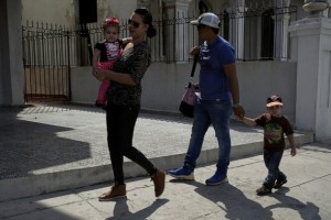 A Cuban family walks down a street in the neighborhood of Vedado, in the Plaza de La Revolución municipality, in Havana, Cuba, where just 49 per cent of children grow up in households with both parents. Credit: Jorge Luis Baños/IPS