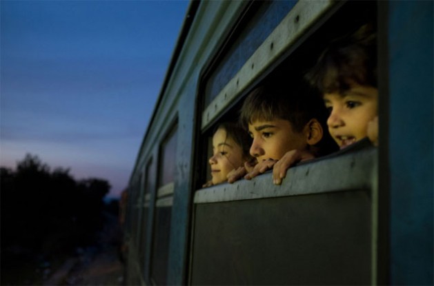In the former Yugoslav Republic of Macedonia, three children look out of the window of a train, which was boarded by refugees primarily from Syria, Afghanistan and Iraq, at a reception centre for refugees and migrants, in Gevgelija. Credit: UNICEF/Ashley Gilbertson VII