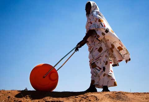 A woman in El Fasher, North Darfur, uses a Water Roller for easily and efficiently carrying water. Credit: UN Photo/Albert Gonzalez Farran.