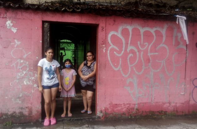 Jennifer Maldonado (I), her little sister and Carmen Carbajal, at the entrance to her home in San Salvador. They hung a white flag as a sign that they had run out of food during the quarantine adopted by the government since March 21 to contain the COVID-19 infections, as did many families in El Salvador and neighbouring Guatemala. This year marks the 25th anniversary of the Beijing Declaration and Platform for Action. It was supposed to have been a ground-breaking year for gender equality, but the coronavirus pandemic has instead widened inequalities for girls and women across every sphere. Credit: Edgardo Ayala / IPS